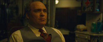 Movie still from “A Most Violent Year” (2014), directed by J.C. Chandor – A bald man in a suit and tie looking at the camera; Close Up shot, Low angle