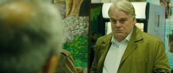 Movie still from “A Most Wanted Man” (2014), directed by Anton Corbijn – A man with a white shirt and a green jacket; Close Up shot, Over the shoulder angle