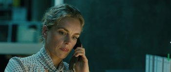 Movie still from “A Most Wanted Man” (2014), directed by Anton Corbijn – A woman talking on a cell phone while wearing a polka dot shirt; Close Up shot, Over the shoulder angle