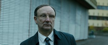 Movie still from “A Most Wanted Man” (2014), directed by Anton Corbijn – An older man wearing a suit and tie; Close Up shot, Low angle