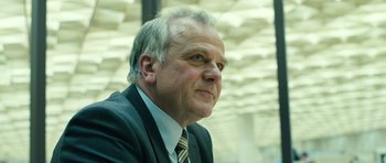 Movie still from “A Most Wanted Man” (2014), directed by Anton Corbijn – An older man wearing a suit and tie looking to his left; Close Up shot, Low angle