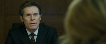 Movie still from “A Most Wanted Man” (2014), directed by Anton Corbijn – A man wearing a suit and tie sitting in front of a woman; Close Up shot, Over the shoulder angle