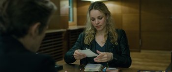 Movie still from “A Most Wanted Man” (2014), directed by Anton Corbijn – A woman sitting at a table looking at a piece of paper; Close Up shot, Over the shoulder angle