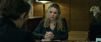 Movie still from “A Most Wanted Man” (2014), directed by Anton Corbijn – A beautiful young lady sitting at a wooden table; Close Up shot, Over the shoulder angle