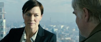 Movie still from “A Most Wanted Man” (2014), directed by Anton Corbijn – A person wearing a suit and tie; Close Up shot, Over the shoulder angle