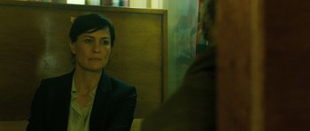 Movie still from “A Most Wanted Man” (2014), directed by Anton Corbijn – A woman in a suit looking into a mirror; Close Up shot, Over the shoulder angle