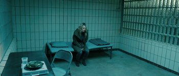 Movie still from “A Most Wanted Man” (2014), directed by Anton Corbijn – A woman sitting on a bench in a room; Wide shot, High angle