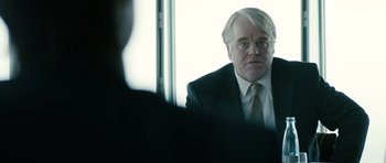Movie still from “A Most Wanted Man” (2014), directed by Anton Corbijn – A man in a suit sitting in front of a window; Close Up shot, Over the shoulder angle