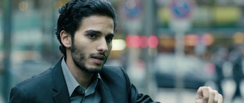 Movie still from “A Most Wanted Man” (2014), directed by Anton Corbijn – A person wearing a suit and tie; Close Up shot, Over the shoulder angle