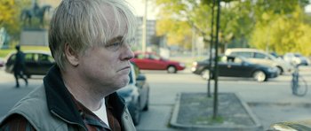 Movie still from “A Most Wanted Man” (2014), directed by Anton Corbijn – A person on the side of the street; Close Up shot, Over the shoulder angle