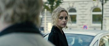 Movie still from “A Most Wanted Man” (2014), directed by Anton Corbijn – A woman in a black jacket is looking at the camera; Close Up shot, Over the shoulder angle