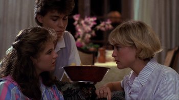 Movie still from “A Nightmare on Elm Street” (1984), directed by Wes Craven – Three people sitting in a living room with a bowl of food; Close Up shot, Over the shoulder angle