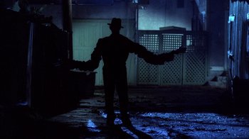 Movie still from “A Nightmare on Elm Street” (1984), directed by Wes Craven – A man standing in the middle of an alley at night; Wide shot, Low angle
