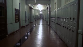 Movie still from “A Nightmare on Elm Street” (1984), directed by Wes Craven – An empty hallway in a school with lockers on either side of the hallway; Extreme Wide shot, High angle