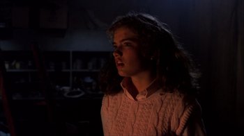 Movie still from “A Nightmare on Elm Street” (1984), directed by Wes Craven – A woman in a pink shirt is standing in a dark room; Close Up shot, Low angle
