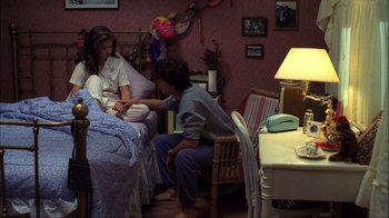 Movie still from “A Nightmare on Elm Street” (1984), directed by Wes Craven – A man sitting on a bed next to a woman in a room; Wide shot, High angle