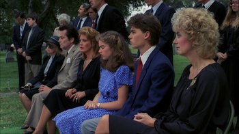 Movie still from “A Nightmare on Elm Street” (1984), directed by Wes Craven – A group of people sitting in a row on the grass; Medium shot, High angle