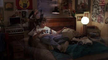 Movie still from “A Nightmare on Elm Street” (1984), directed by Wes Craven – A person sitting on a bed with a phone; Wide shot, High angle