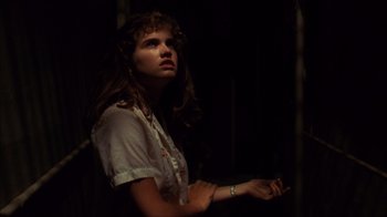 Movie still from “A Nightmare on Elm Street” (1984), directed by Wes Craven – A woman with long hair is smoking a cigarette in a dark room; Close Up shot, Low angle