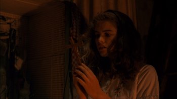 Movie still from “A Nightmare on Elm Street” (1984), directed by Wes Craven – A woman looking into a mirror in a dark room; Close Up shot, Over the shoulder angle