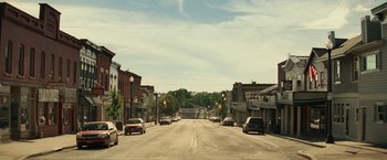 Movie still from “A Quiet Place Part II” (2020), directed by John Krasinski – A view of an empty street with cars parked on the side of the road; Extreme Wide shot, Low angle