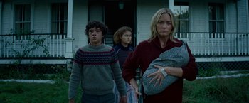 Movie still from “A Quiet Place Part II” (2020), directed by John Krasinski – A group of people standing in front of a building; Medium shot, Low angle