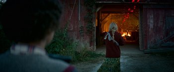 Movie still from “A Quiet Place Part II” (2020), directed by John Krasinski – A woman standing in front of an old red barn; Wide shot, Over the shoulder angle
