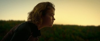 Movie still from “A Quiet Place Part II” (2020), directed by John Krasinski – A young girl is looking out over a field at sunset; Close Up shot, Low angle