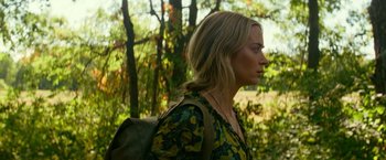 Movie still from “A Quiet Place Part II” (2020), directed by John Krasinski – A woman in a yellow and green dress with a backpack; Close Up shot, Over the shoulder angle