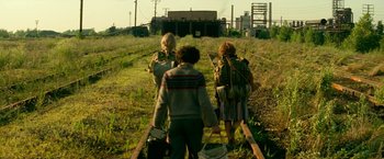 Movie still from “A Quiet Place Part II” (2020), directed by John Krasinski – A group of people walking across a grass covered field; Wide shot, Low angle