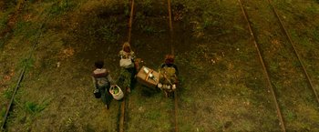 Movie still from “A Quiet Place Part II” (2020), directed by John Krasinski – Two children and a woman are walking on the train tracks; Wide shot, Overhead angle