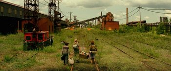 Movie still from “A Quiet Place Part II” (2020), directed by John Krasinski – Three people are walking down the train tracks; Extreme Wide shot, High angle