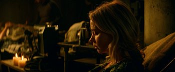 Movie still from “A Quiet Place Part II” (2020), directed by John Krasinski – A woman sitting in a dark room looking down at the ground; Close Up shot, Over the shoulder angle