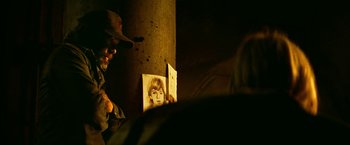 Movie still from “A Quiet Place Part II” (2020), directed by John Krasinski – A man looking at a picture of a woman; Close Up shot, Over the shoulder angle