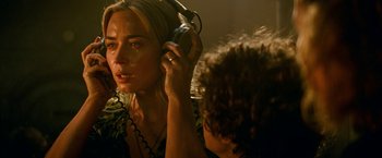 Movie still from “A Quiet Place Part II” (2020), directed by John Krasinski – A woman with headphones is crying while another woman looks on; Close Up shot, Over the shoulder angle