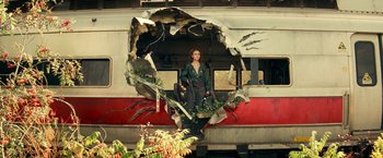 Movie still from “A Quiet Place Part II” (2020), directed by John Krasinski – A woman standing in front of a broken train window; Wide shot, Low angle