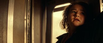 Movie still from “A Quiet Place Part II” (2020), directed by John Krasinski – A woman with curly hair standing on a train; Close Up shot, Low angle