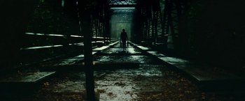 Movie still from “A Quiet Place Part II” (2020), directed by John Krasinski – A person is walking on a train track in the dark; Extreme Wide shot, Low angle