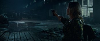 Movie still from “A Quiet Place Part II” (2020), directed by John Krasinski – A woman is holding a gun in a dark place; Medium shot, Over the shoulder angle