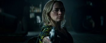 Movie still from “A Quiet Place Part II” (2020), directed by John Krasinski – A woman holding a gun while standing in a dark room; Close Up shot, Over the shoulder angle