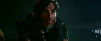 Movie still from “A Quiet Place Part II” (2020), directed by John Krasinski – A man with long hair and a beard is holding a rope; Close Up shot, Low angle