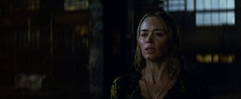 Movie still from “A Quiet Place Part II” (2020), directed by John Krasinski – A woman in a yellow and black floral dress looking sad; Close Up shot, Low angle