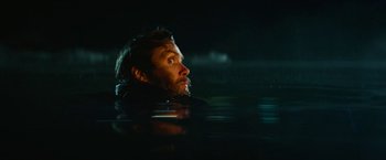 Movie still from “A Quiet Place Part II” (2020), directed by John Krasinski – A man in the water looking up at the sky at night; Close Up shot, Over the shoulder angle