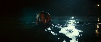 Movie still from “A Quiet Place Part II” (2020), directed by John Krasinski – A man swimming in a body of water at night; Close Up shot, Low angle