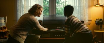 Movie still from “A Quiet Place Part II” (2020), directed by John Krasinski – A woman and a young boy are looking at a record player; Medium shot, Over the shoulder angle