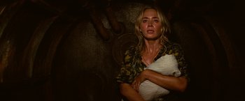 Movie still from “A Quiet Place Part II” (2020), directed by John Krasinski – A woman holding a pillow in front of a wall; Medium shot, High angle