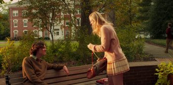 Movie still from “A Rainy Day in New York” (2019), directed by Woody Allen – Two people on a park bench with a purse; Medium shot, Over the shoulder angle