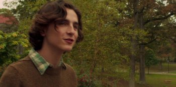 Movie still from “A Rainy Day in New York” (2019), directed by Woody Allen – A man in a brown shirt is looking to his left; Close Up shot, Over the shoulder angle