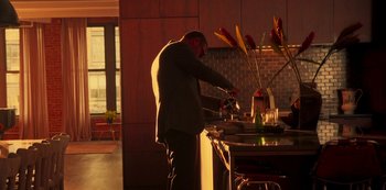 Movie still from “A Rainy Day in New York” (2019), directed by Woody Allen – A man standing in front of a kitchen sink; Wide shot, High angle