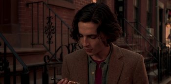 Movie still from “A Rainy Day in New York” (2019), directed by Woody Allen – A man in a jacket and tie smoking a cigarette; Close Up shot, Over the shoulder angle